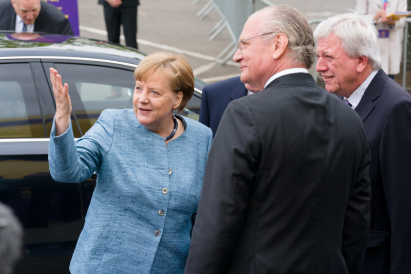 Reportagefotografie: Bundeskanzlerin Angela Merkel auf der Feier zum 350jährigen Jubiläum der Firma Merck in Darmstadt. Bei der Begrüßung zeigt sie auf das extra aufgebaute Festzelt.