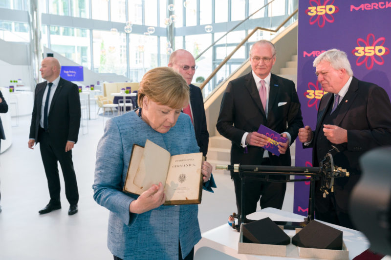 editorial photography:  German Chancellor Angela Merkel at the celebration of the 350th anniversary of Merck in Darmstadt. She is looking at a book from the company