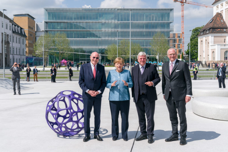 Reportagefotografie: Bundeskanzlerin Angela Merkel auf der Feier zum 350jährigen Jubiläum der Firma Merck in Darmstadt. Die Gastgeber stoppen mit ihr für ein Gruppenfoto vor der Firmenzentrale.