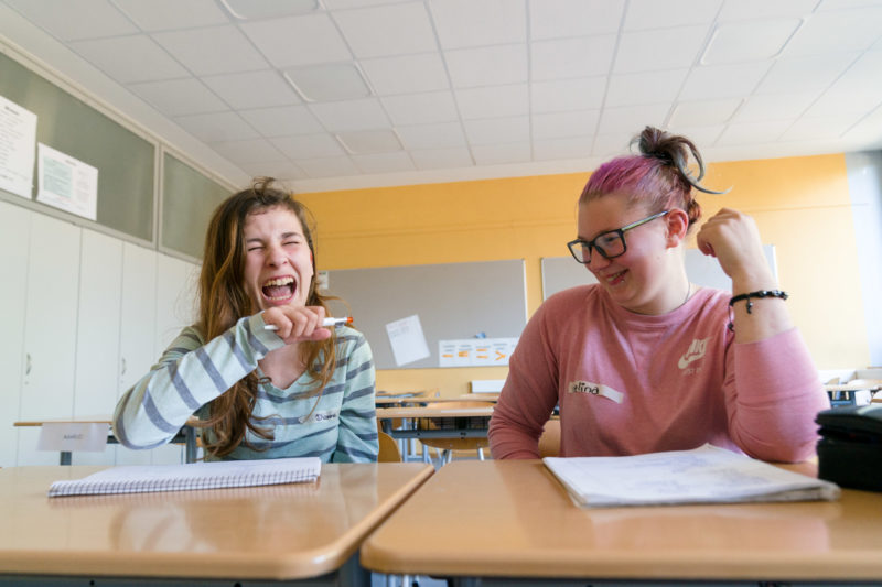 Reportagefotografie zum Thema Lernen und Bildung: Zwei Schülerinnen haben während einem Poetry-Slam Workshop großen Spaß.