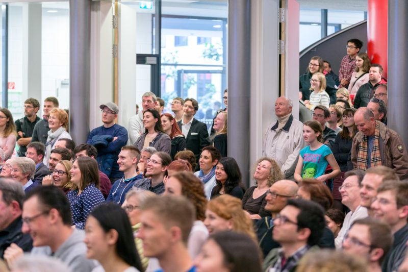 Editorial photography as event photography and fair photography: Spectators enjoy a science slam at the Open Day of a research institute.