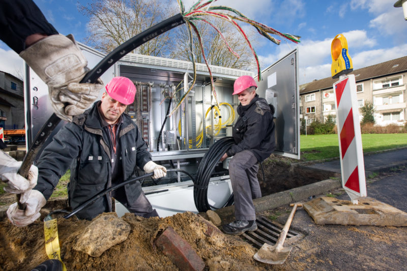 Industriefotografie: Techniker der Deutschen Telekom AG verlegen Daten- und Telefonkabel.