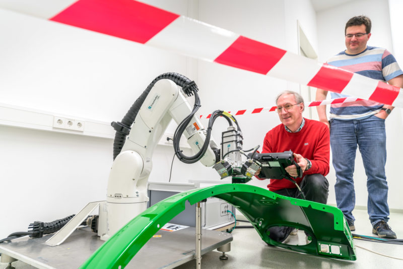 Wissenschaftsfotografie: Mitarbeiter an einem Roboter mit Terahertz-Messtechnik zur Qualitätsmessung in der Blechverarbeitung am Fraunhofer-Institut für Techno- und Wirtschaftsmathematik ITWM in Kaiserslautern.