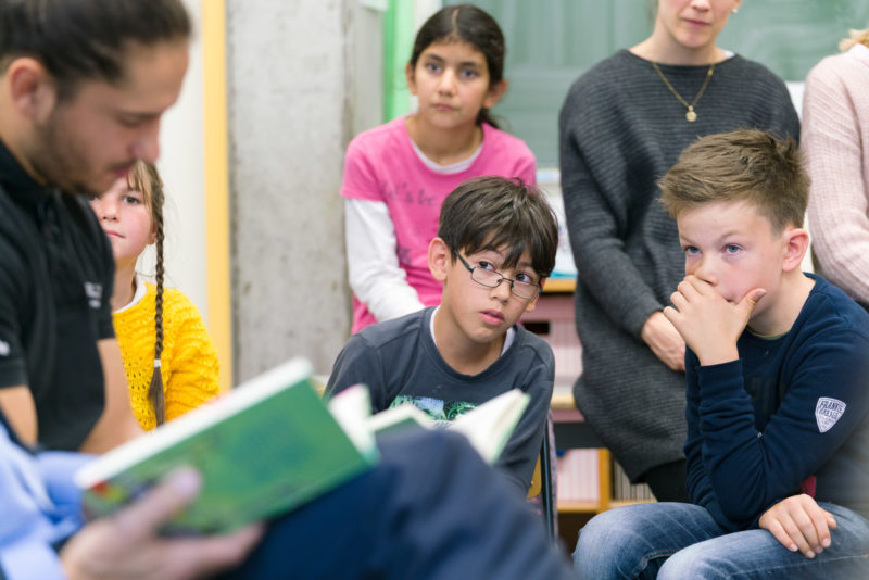 Editorial photography, subject learning and education: During a reading lesson at a primary school, children listen attentively and thoughtfully