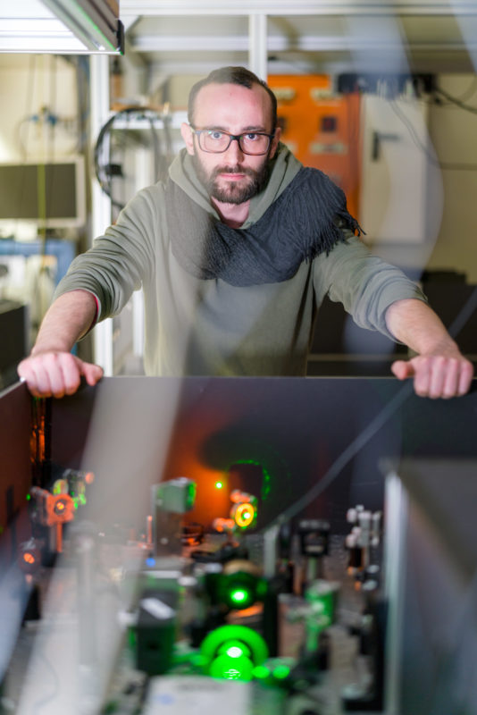 Science photography at a physics institute of the University of Stuttgart: Portrait of a researcher in a laser laboratory.